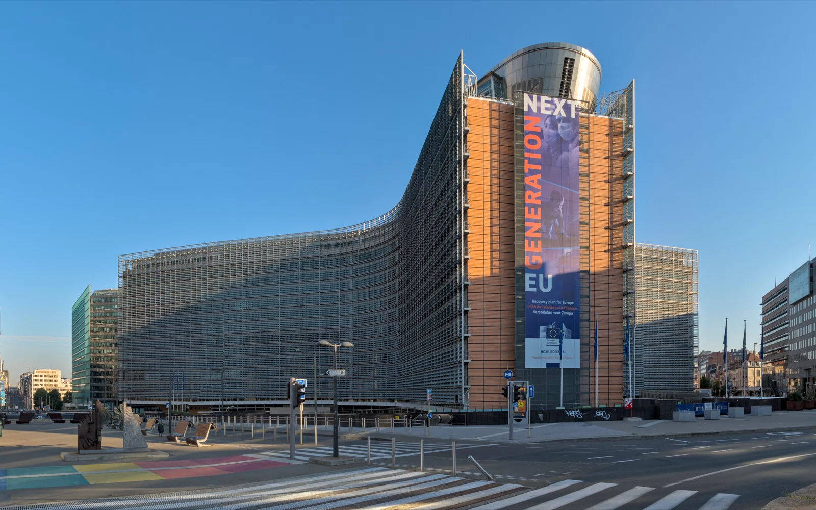 Buet kontorbygning med et Next Generation EU-banner, sett fra gaten.