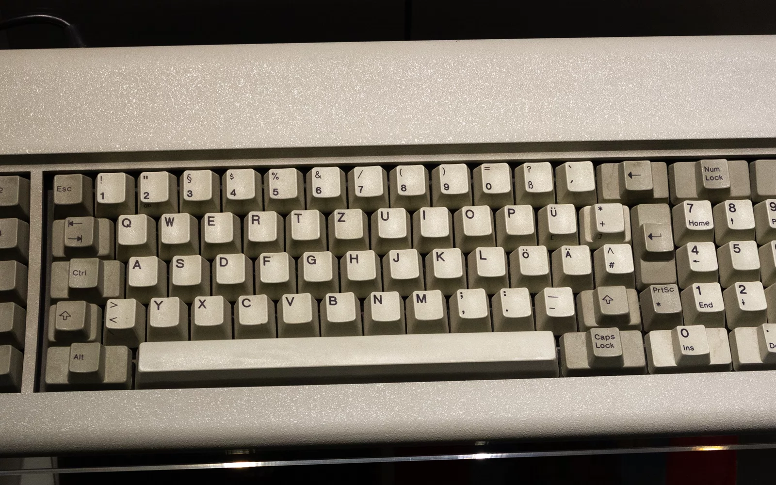 Eldre beige tastatur med tysk tasteoppsett, fotografert ovenfra.