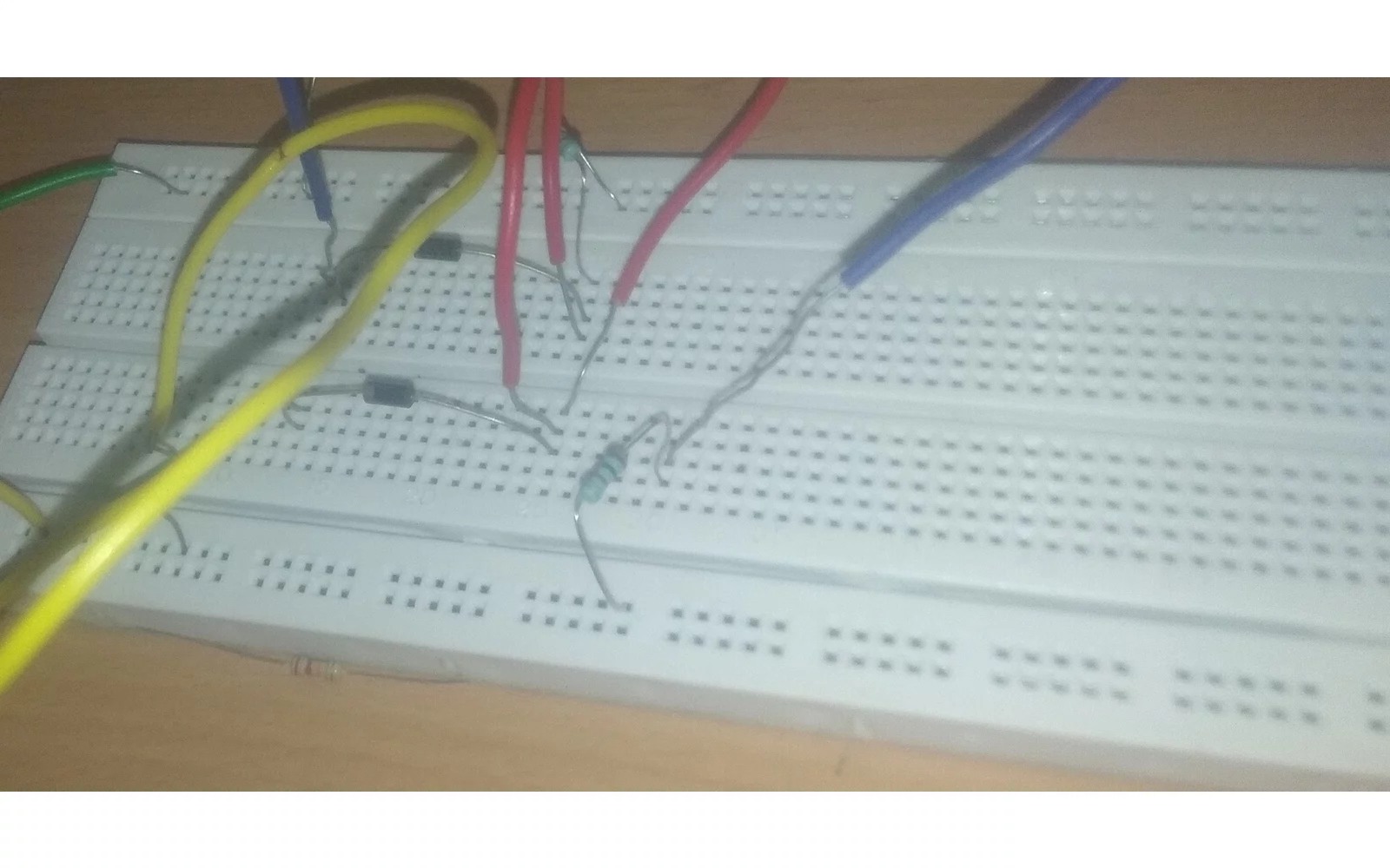 Et hvitt koblingsbrett med ledninger og elektroniske komponenter på et trebord. Illustrasjonsfoto – ikke fra hendelsen.